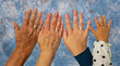 Vier Hände im Alter von jeweils 93 Jahren, 63 Jahren, 33 Jahren und 2 Jahren vor einem blaum marmorierten Hintergrund 