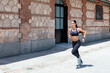 © David Espejo/ADDICTIVE STOCK - Side view of fit female in sportswear running fast along pavement during training on sunny day in city