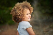 © Gabriel Trujillo/ADDICTIVE STOCK - Adorable little girl with blonde Afro hair smiling and looking away while spending summer day in nature