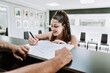 © Ivan Pujol/ADDICTIVE STOCK - Young female standing at counter in tattoo salon and signing document before procedure