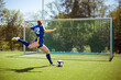 © Joe Urrutia/ADDICTIVE STOCK - Side view of unrecognizable female athlete shooting ball into goal while playing football on field
