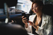 © M√úR/ADDICTIVE STOCK - Determined female entrepreneur in elegant costume sitting in modern automobile and browsing mobile phone while checking messages and working remotely