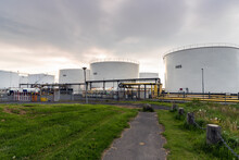 White Oil Storage Tanks In A Industrial Area At Sunset