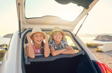Two Smiling Kids In Straw Hats Leaning In The Back Seats Of A Car Sticking Their Heads Out Of The Trunk With An Expression Of Happiness