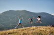 © Alberto Garrido/ADDICTIVE STOCK - Company of delighted friends jumping on hill in mountains while enjoying freedom during summer vacation