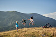 © Alberto Garrido/ADDICTIVE STOCK - Company of delighted friends jumping on hill in mountains while enjoying freedom during summer vacation