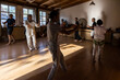 © David Fuentes/ADDICTIVE STOCK - Full body of mature male instructor with group of diverse people performing chi kung pose during practice in studio