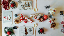 Top View Composition With Decorative Snowflake And Wooden Fox Figure Hanging On Pine Tree Branch Arranged Near Spoon On Table During Christmas Celebration