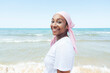 © Jose Luis CARRASCOSA/ADDICTIVE STOCK - Determined ethnic female with headdress and piercing standing on beach on background of sea and looking at camera