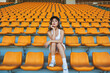 © Luis Gomez/ADDICTIVE STOCK - Confident Asian athletic woman in sportswear sitting on stadium seat while resting after workout and looking at camera