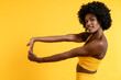 © Luis Manuel Munoz/ADDICTIVE STOCK - Black female in yellow sportswear posing and looking away against yellow background