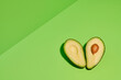 © Si And Si/ADDICTIVE STOCK - Fresh green natural avocado cut in half with seed placed on bright green background