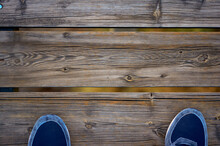 Detail Of Some Feet With Slippers Crossing A Wooden Bridge