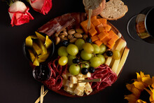 Wooden Board With Different Types Of Cheese, Cold Meats, Bread And Wine
