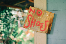 Old Wooden Sign With 'No Shoes' Words On It