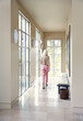 © Trinette Reed/Stocksy - Woman walking down hallway in luxury home