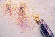 © Wizemark/Stocksy - Shiny glitter spilled on the table from a tiny glass bottle