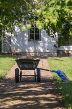 Wheelbarrow And Shovel On A Garden Path