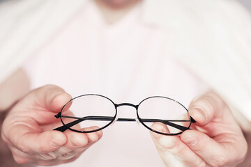 The concept of poor vision. Hold a contact lens and glasses in hand. A poster for advertising glasses and lenses.