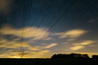 © Liam Grant Photography/Stocksy - Electricity pylons, stars and clouds. West Acre, Norfolk, UK.