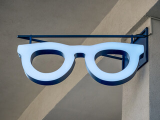 Sign in the shape of an eyeglasses frame on a wall.