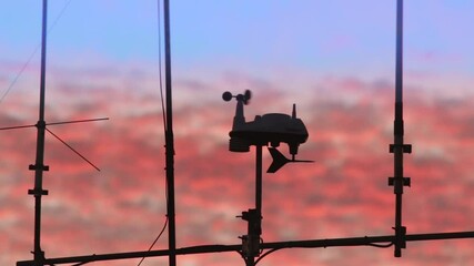 close up shot of a weather station and aerials. weather station wind vane moving fast.