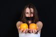 © polakravis - portrait of a girl in a white T-shirt with a black bandage on her mouth holding oranges in her hands