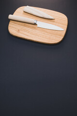 Poster - Vertical shot of a wooden cutting board and a knife