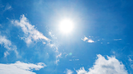 nature background of clouds with clear blue sky background and sun with lens flare.