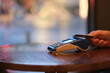 close up people using credit card to pay over pos terminal on bar counter. defocused background