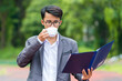 © shine - Asian businessman reading documents and drinking coffee at outdoor.