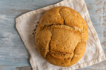 Homemade traditional round bread on a rustic wooden table