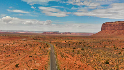 Wall Mural - Countryside road through the fabulous Monument Valley in summser season, aerial view from drone