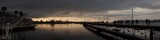 Fototapeta Londyn - panorámica en un pueblo pesquero de su puerto con siluetas de personas paseando al atardecer