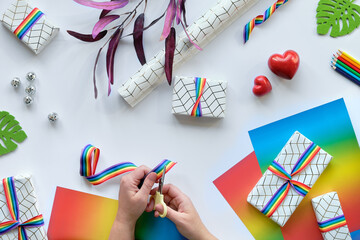 Wall Mural - Christmas gifts with rainbow ribbon in LGBTQ flag colors. Flat lay with Xmas decor on white.