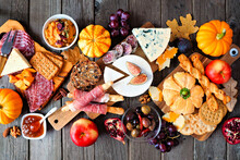 Fall Theme Charcuterie Table Scene Against A Dark Wood Background. Different Cheese And Meat Appetizers. Top Down View.