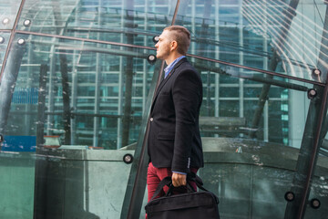 Photo of a young and attractive business man wearing smart clothes with a briefcase ready to start his work day