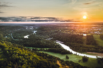 Picturesque valley of Sigulda city in sunrise colors. Panoramic view over pine forest surrounding river Gauja.