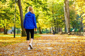 Wall Mural - middle-aged woman walking in city park
