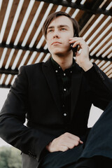 Wall Mural - White young man holds a smartphone in his hand. Selective focus.