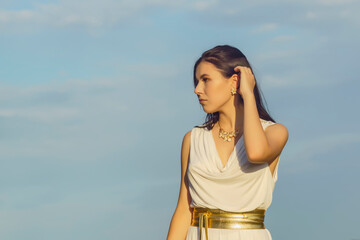 Wall Mural - portrait of a young beautiful woman in a white tunic with a gold belt