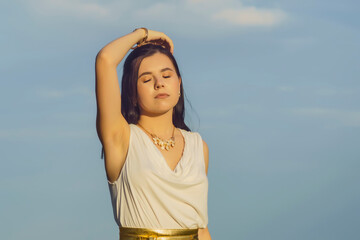 Wall Mural - portrait of a young beautiful woman in a white tunic with a gold belt