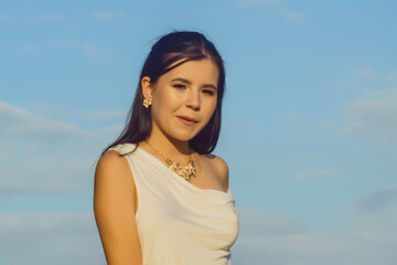 Wall Mural - portrait of a young beautiful woman in a white tunic with a gold belt