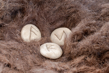 Stone runes on a animal fur. Futhark viking alphabet. Close up photo of Norse runes.