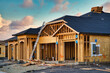 New construction of framing and roofing of residential home in California with beautiful sunset sky