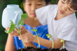 © TinPong - Young Asian boy and girl watering to young seedling.