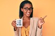 © Krakenimages.com - Young african american woman drinking mug of coffe with i am the boss message smiling happy pointing with hand and finger to the side