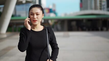 Wall Mural - happy business woman walking and talking with mobile phone in the city