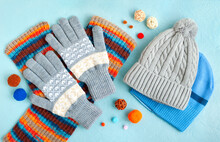 Hats, Gloves And A Scarf On A Textured Background. Warm Clothes For Autumn And Winter In The Form Of Hats, Gloves And A Scarf. Fashionable Set Of Clothes Made Of Hats And Gloves.