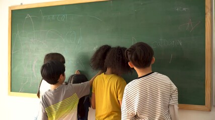 Wall Mural - Multiethnic group of school children using chalkboard in school classroom, education, learning, fun. Diverse elementary students writing on blackboard